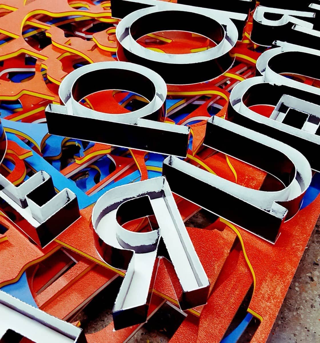 Lettres d'enseigne en relief en cours de fabrication dans un atelier